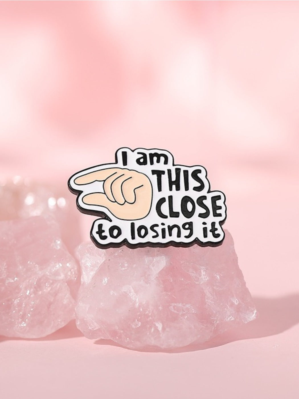 Close-up of Pinori finger brooch showing detailed English letter text 'I Will Close It'