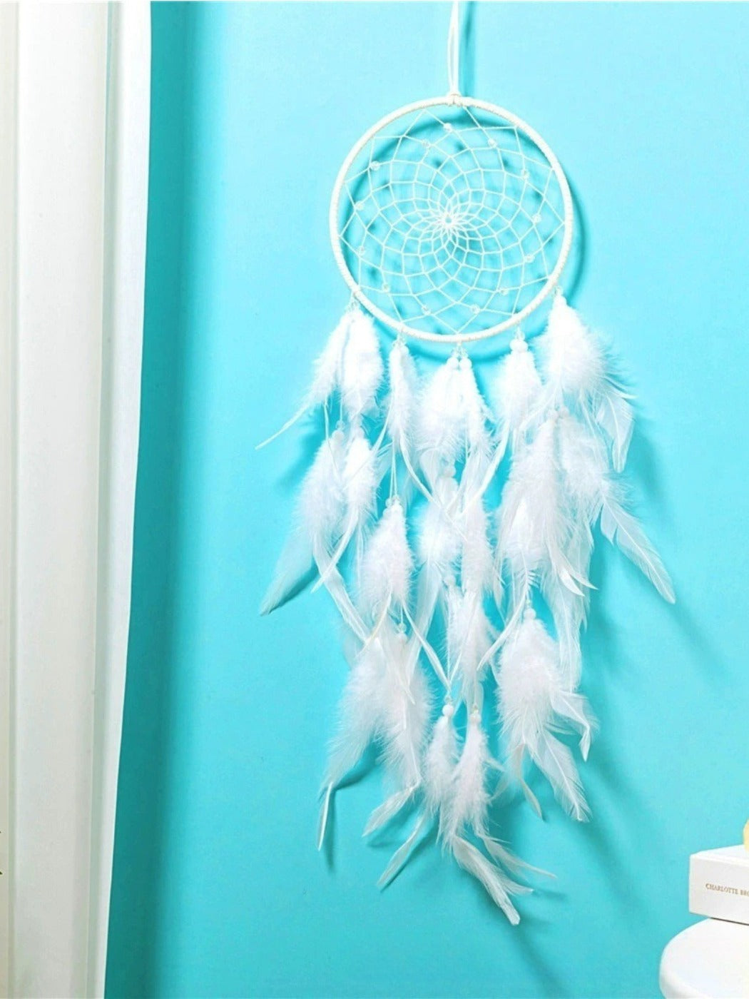 Side angle of Native American style dreamcatcher wind chime with natural wood and feathers