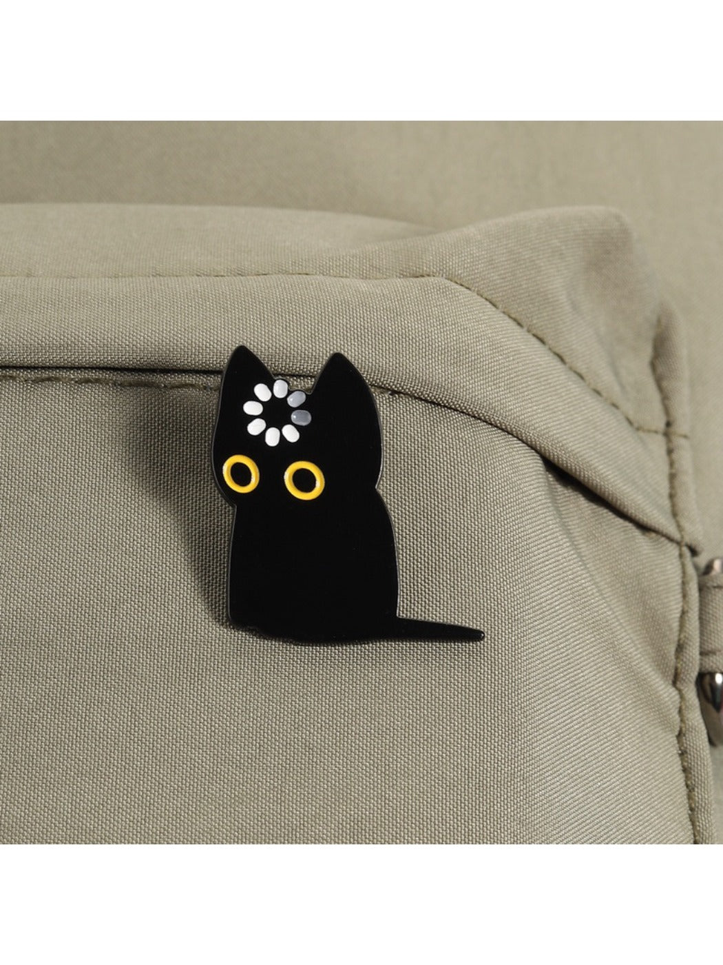 Pinori black cat brooch displayed on fabric surface