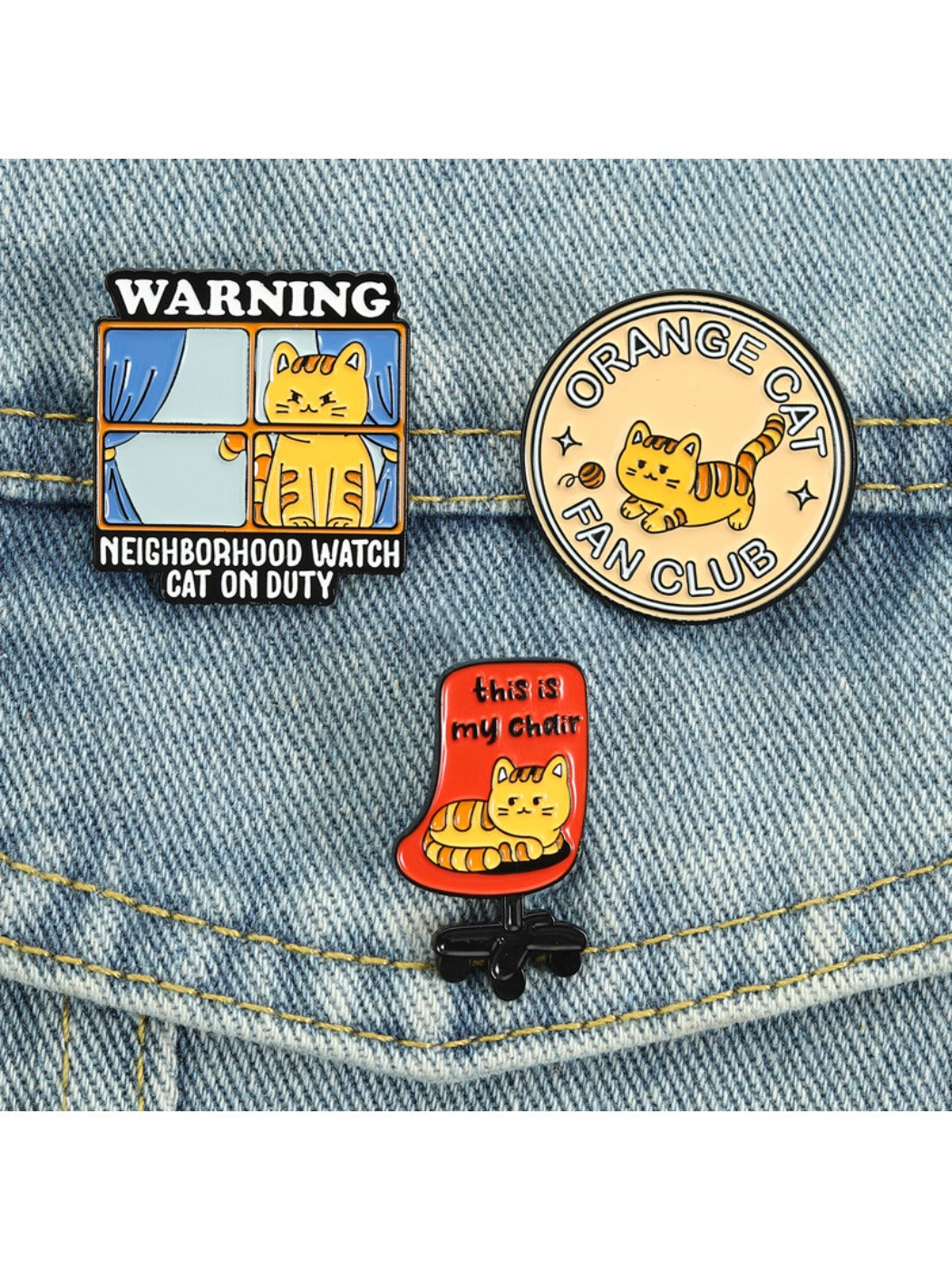 Pinori orange cat enamel pin displayed on a black jacket
