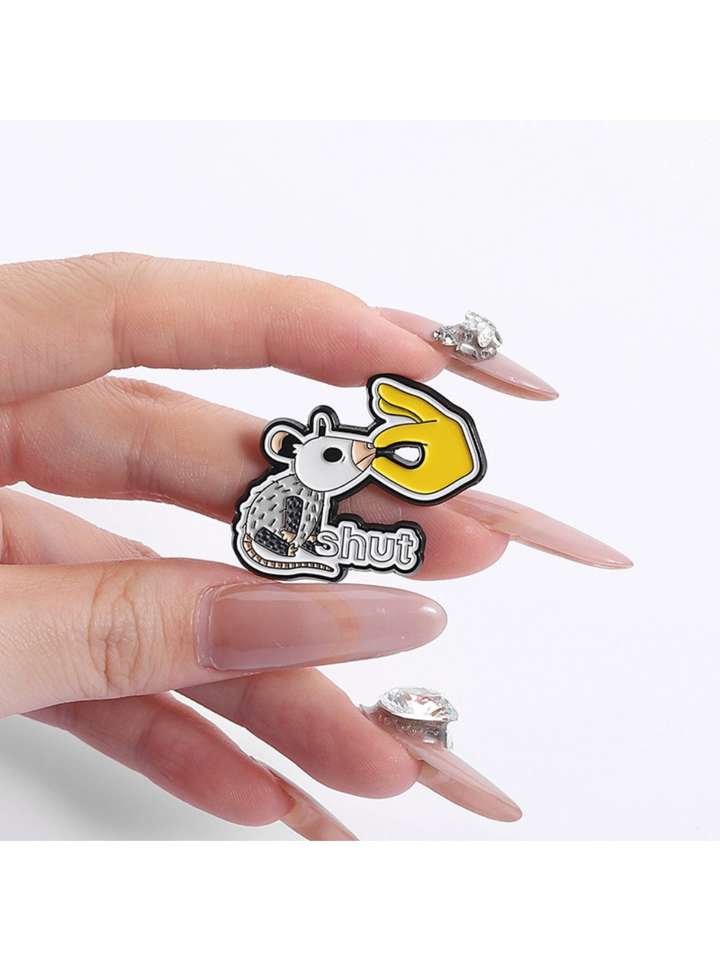 White lab rat pin badge on a corkboard with other pins