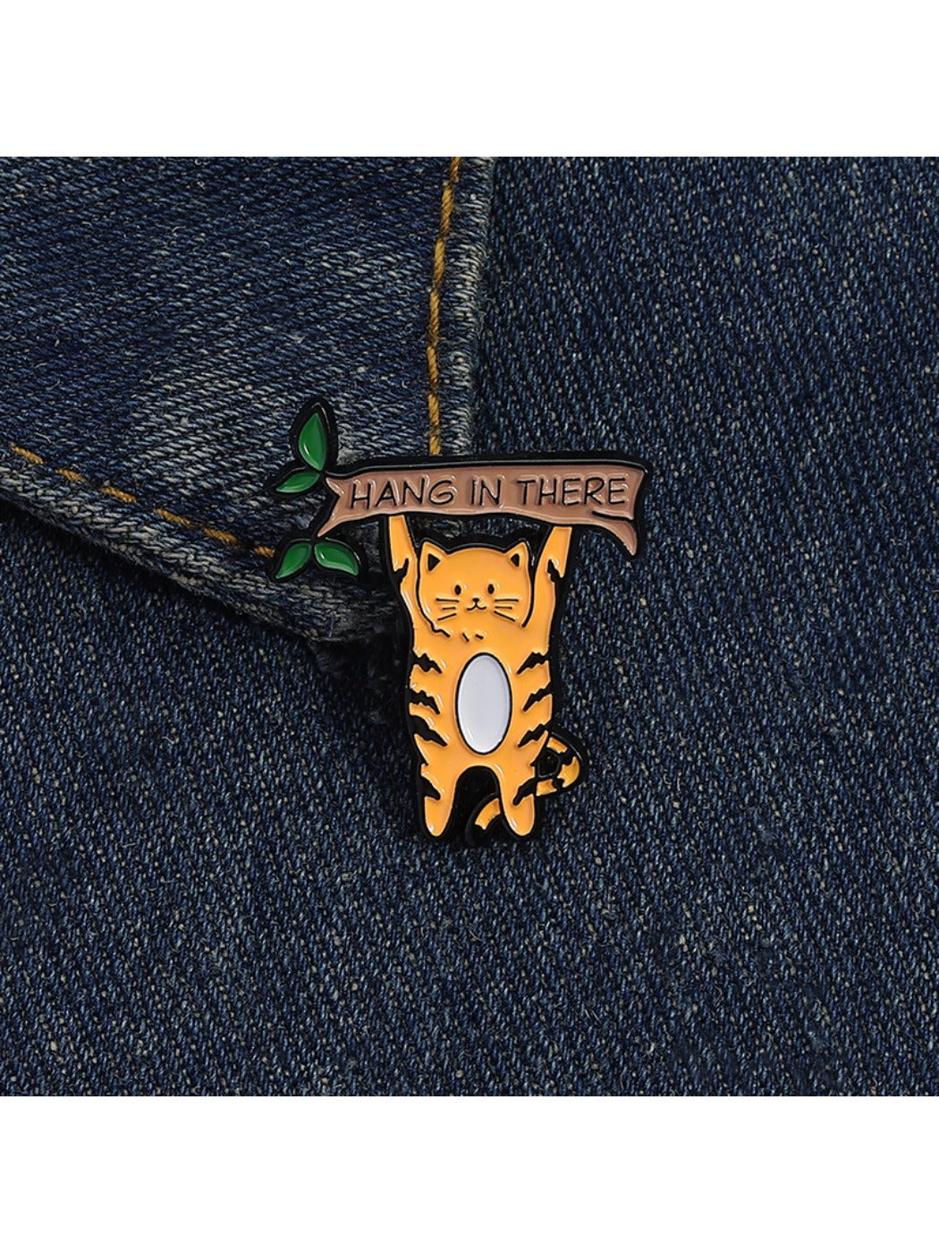 Pinori cat brooch worn on a denim jacket lapel in natural light