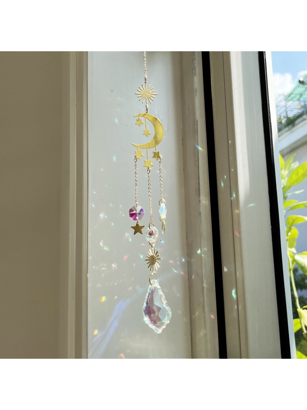 Somnia Star Moon Rainbow Sun Catcher casting rainbow colors on a white wall