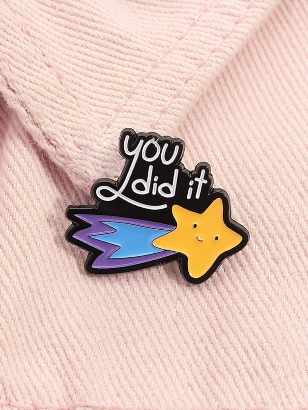 Pinori geometric star pin displayed on a black fabric surface highlighting metallic details