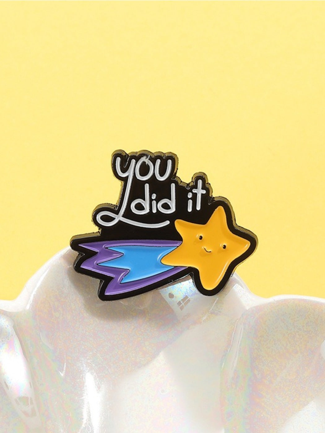 Pinori star brooch worn on a denim jacket lapel in natural light