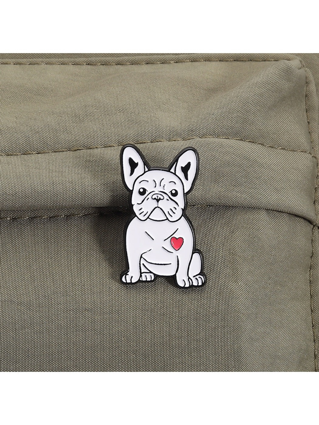 Pinori white pug dog brooch worn on a denim jacket pocket