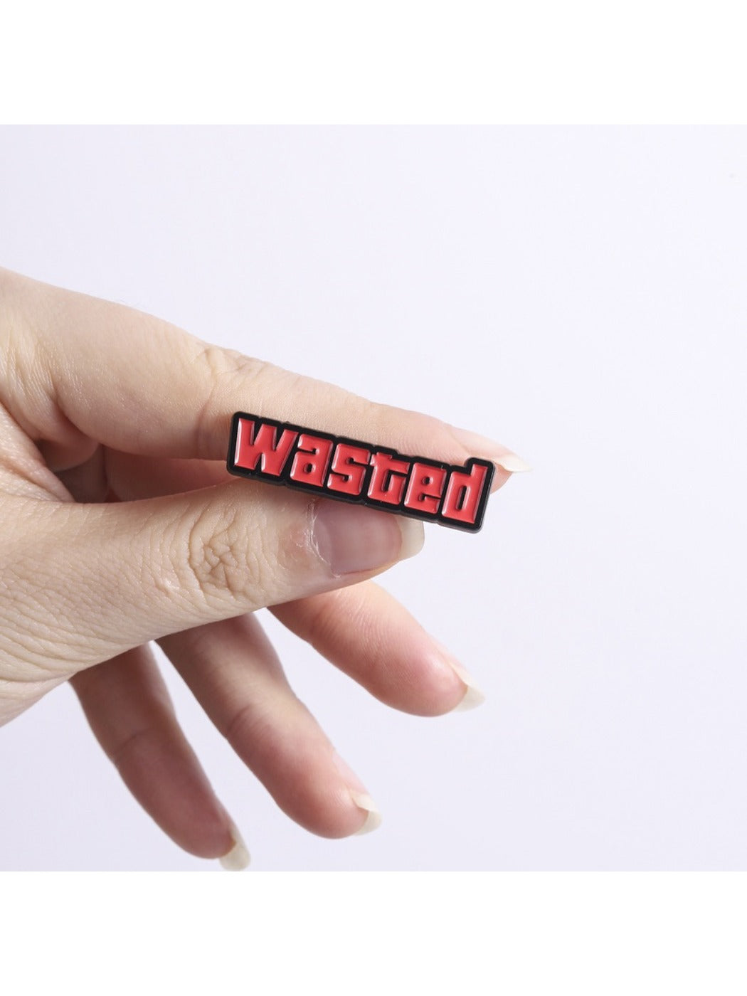 Pinori 'Wasted' badge pinned on a corkboard with other colorful pins