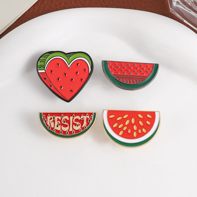 Multiple Styles watermelon enamel pins on a white plate
