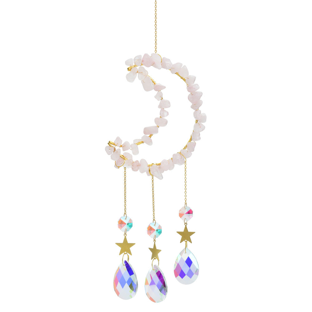 Somnira dreamcatcher with crescent moon shape and hanging feathers displayed outdoors