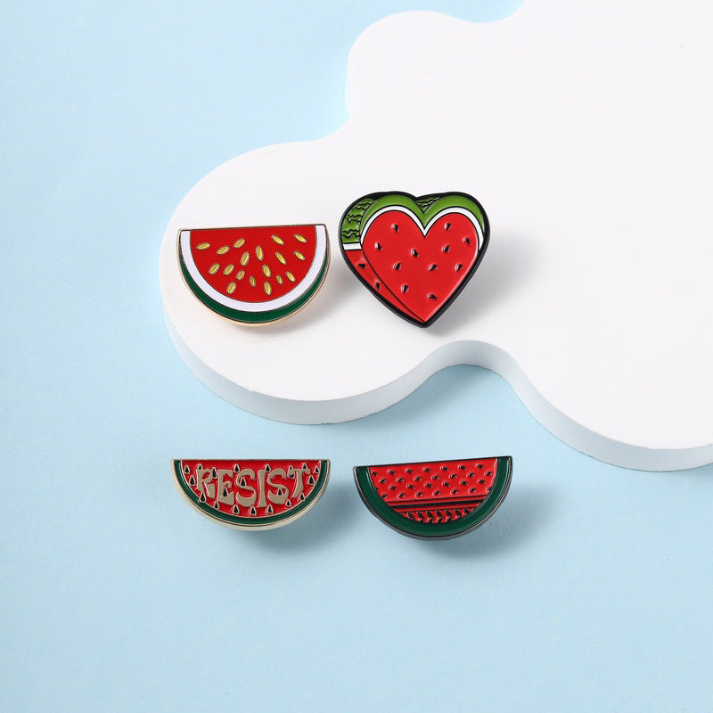 Multiple Styles watermelon enamel pins on a blue display stand