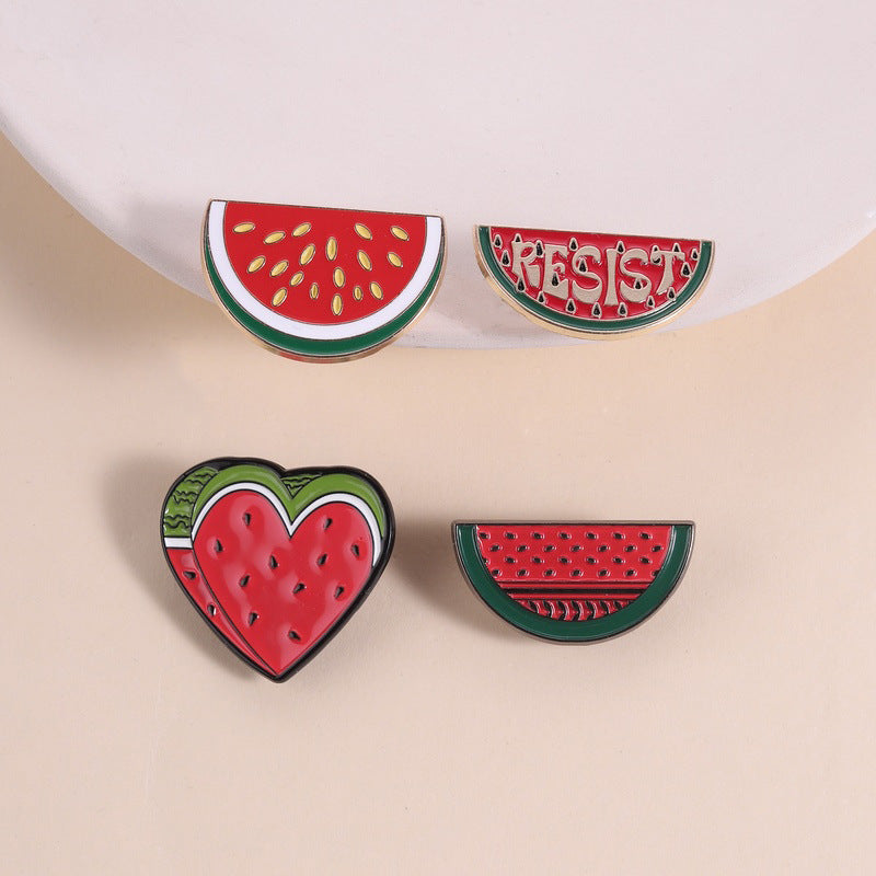 Multiple Styles watermelon enamel pins arranged on a beige surface