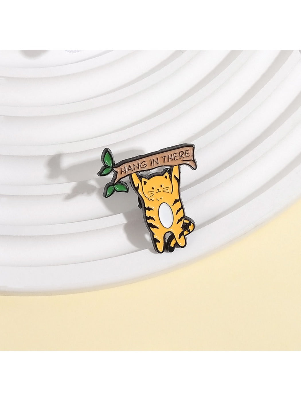 Close-up of Pinori cat brooch showing smooth enamel surface and metal outline