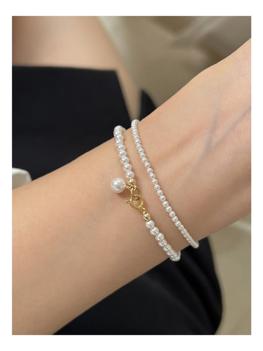 Close-up of Emora delicate minimalist pearl bracelet with tiny beads on a white background