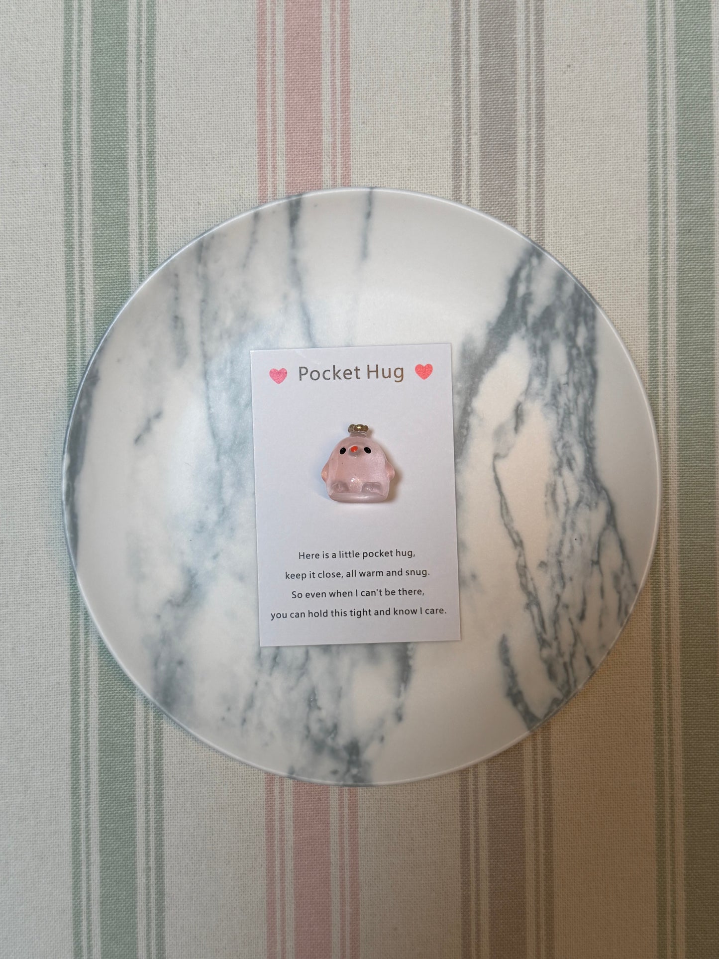 Crown chick token resting on the folded pocket hug card
