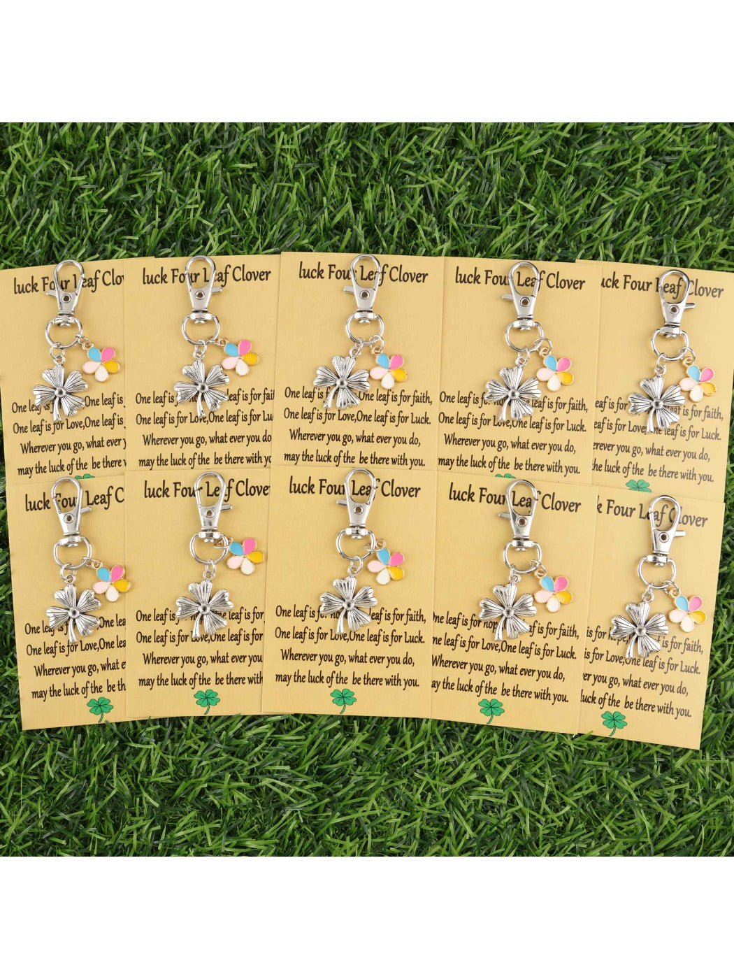 Close-up of colorful flower and lucky clover keychains arranged in a circle on a white surface