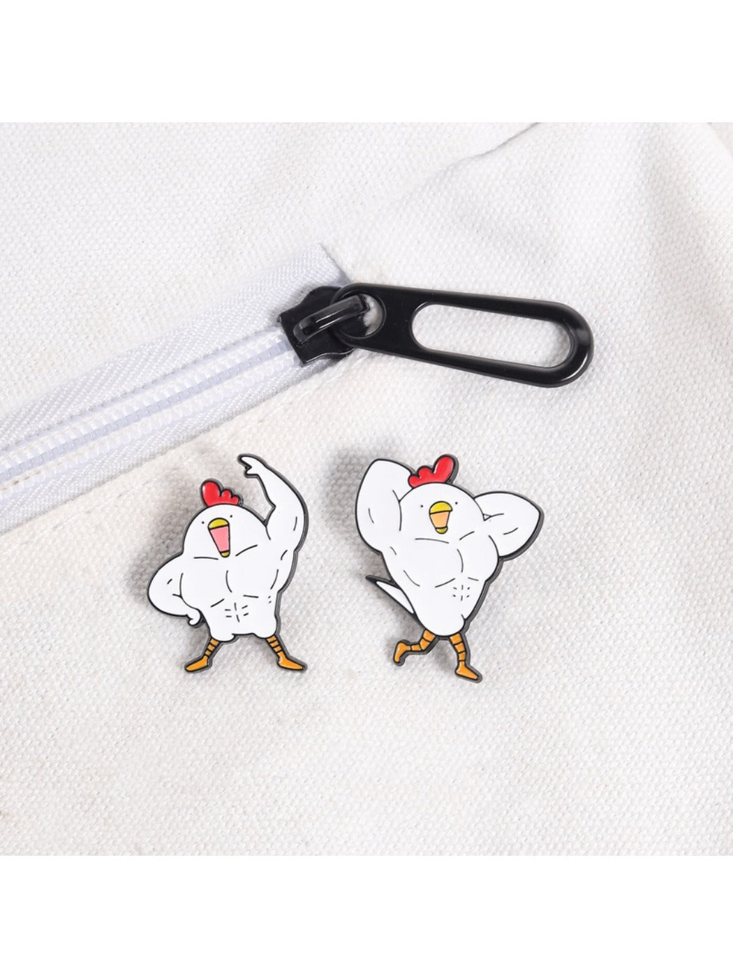 Pinori gym chicken brooch displayed on a black fabric surface