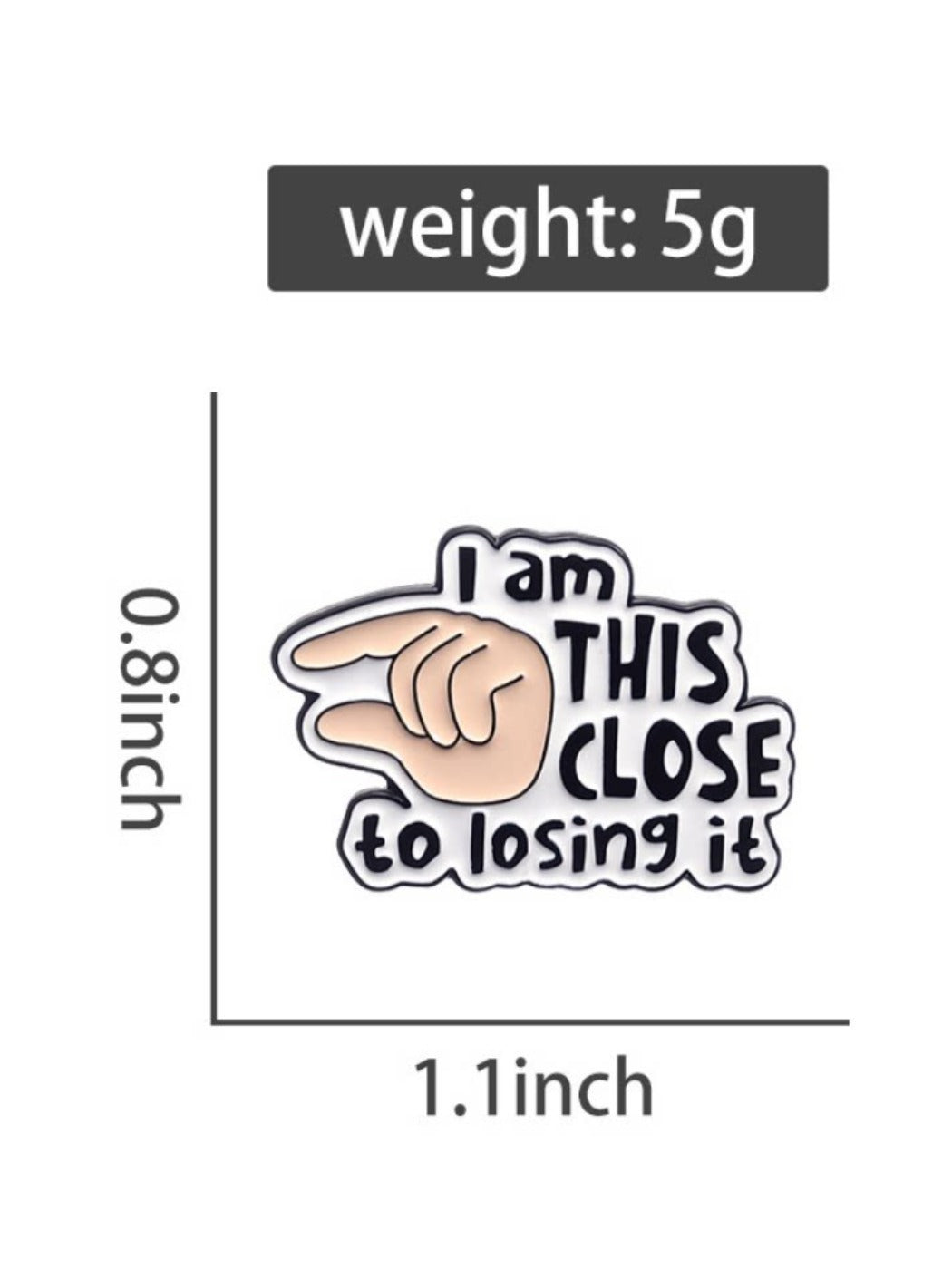 Pinori brooch placed on a flat surface with clear view of text and finger illustration