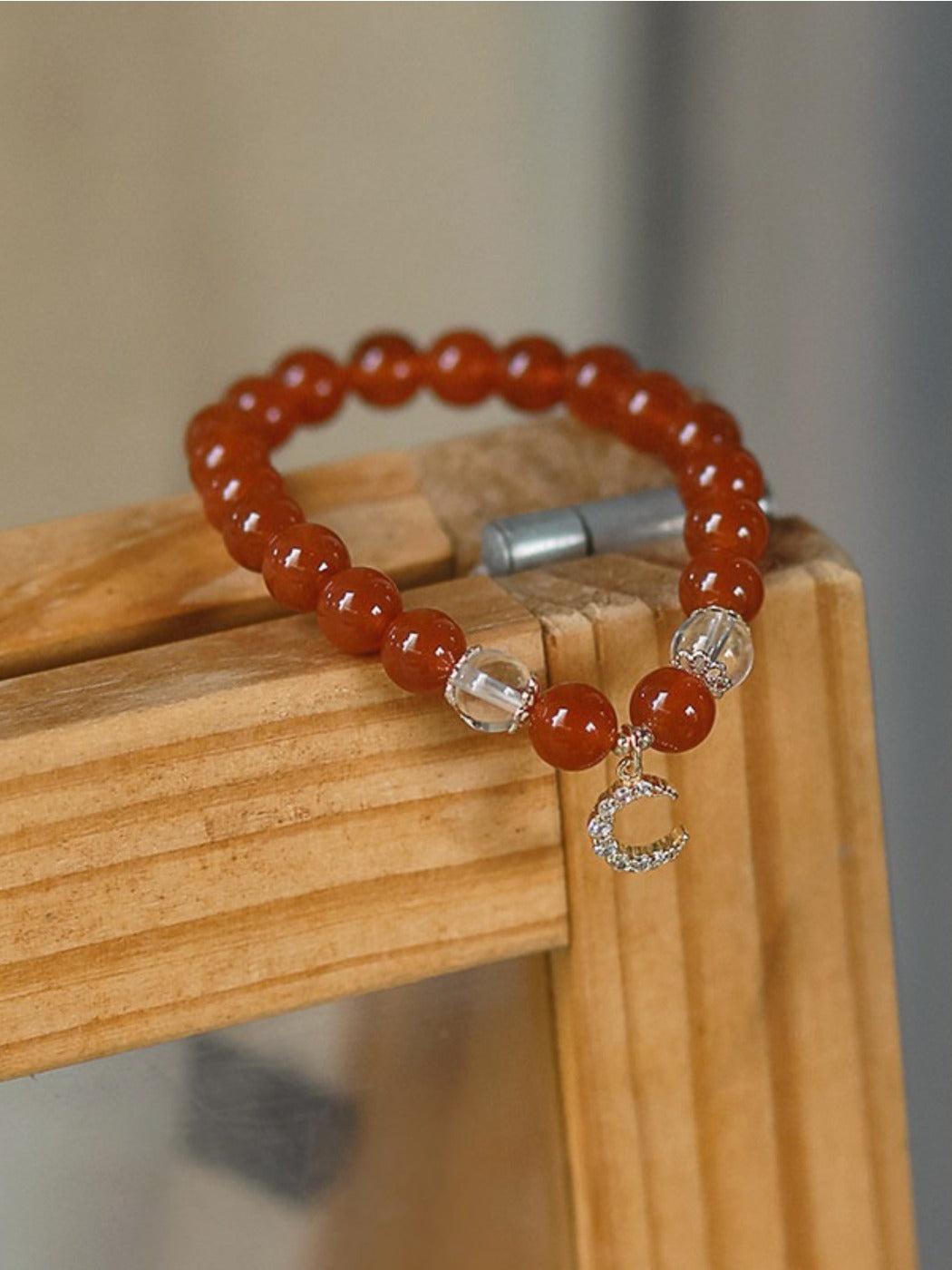 Red agate bracelet worn on a wrist showing bead details and smooth finish