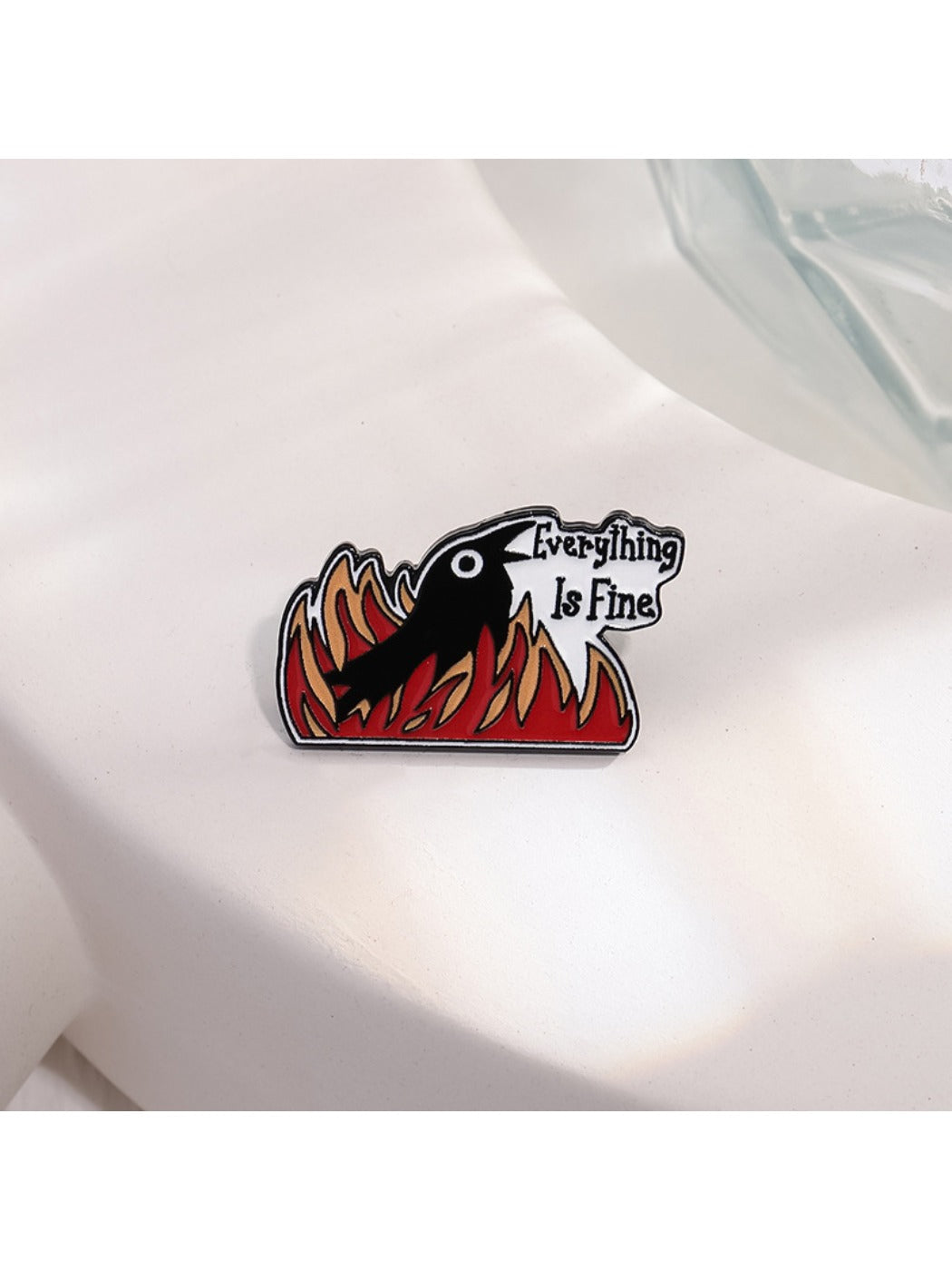 Pinori brooch showing detailed raven design with flames on a white surface