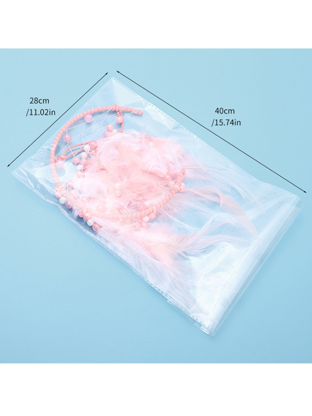 Full view of the pink feather moon shaped dream catcher with hanging strings