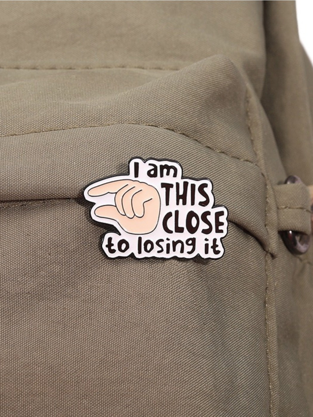 Side view of Pinori pin badge highlighting metal clasp and enamel finish