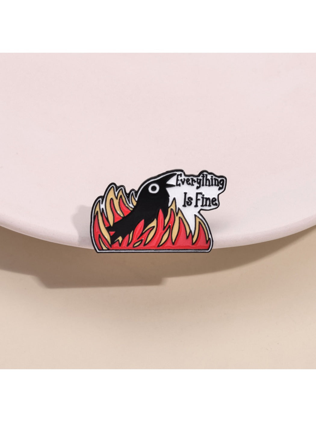 Close-up of Pinori Gothic raven brooch with flame motif on black background