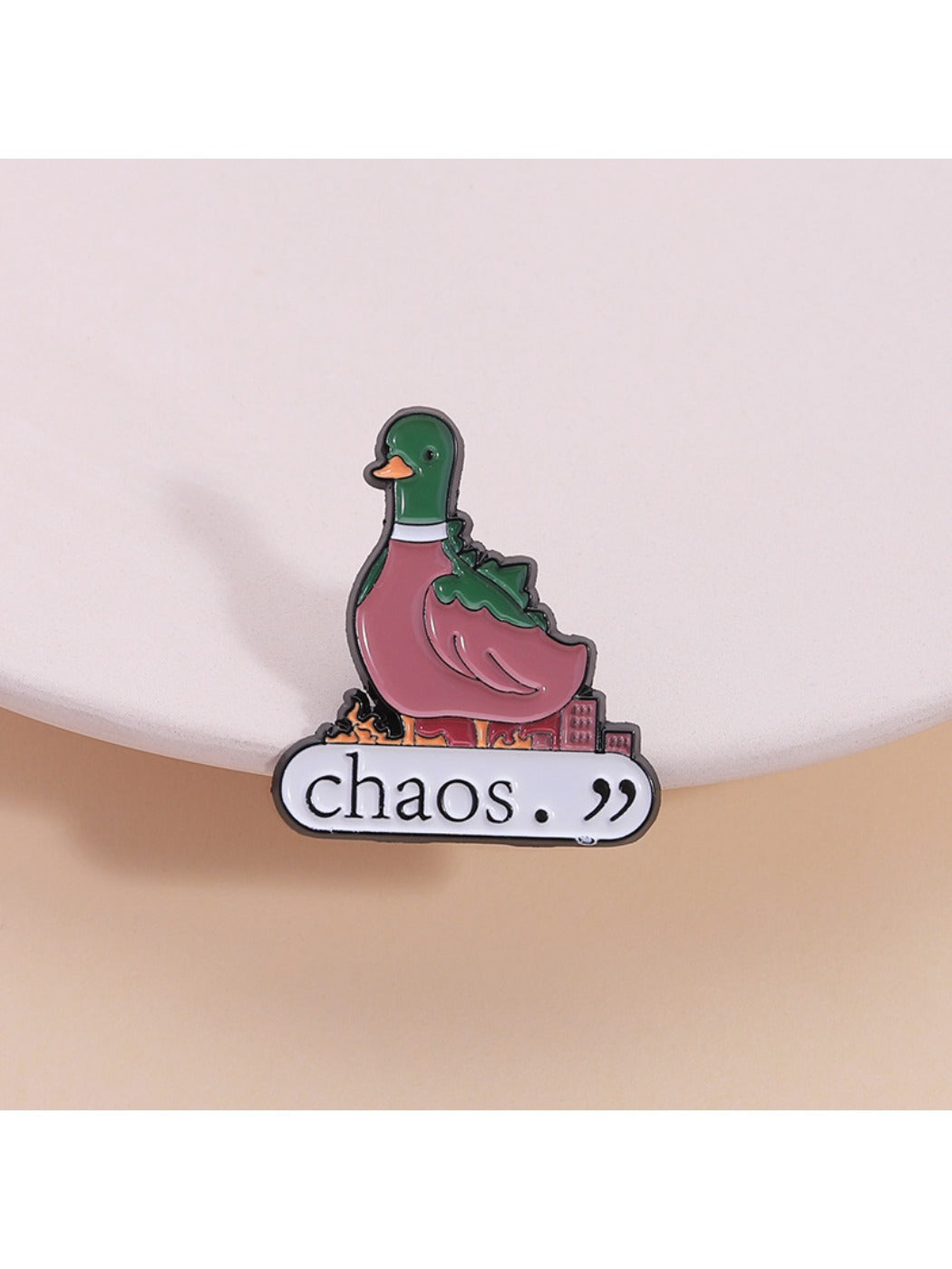Close-up of Pinori cute green duck animal brooch with gold outline on white background