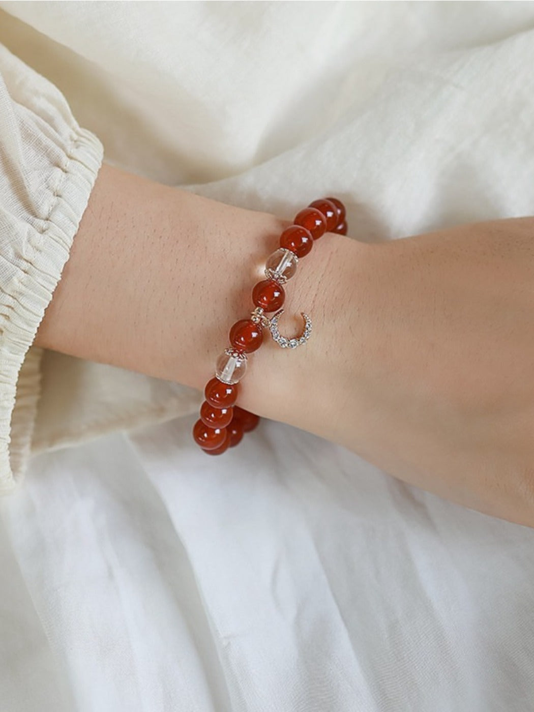Emora stylish red agate bracelet displayed on a wooden surface with natural light