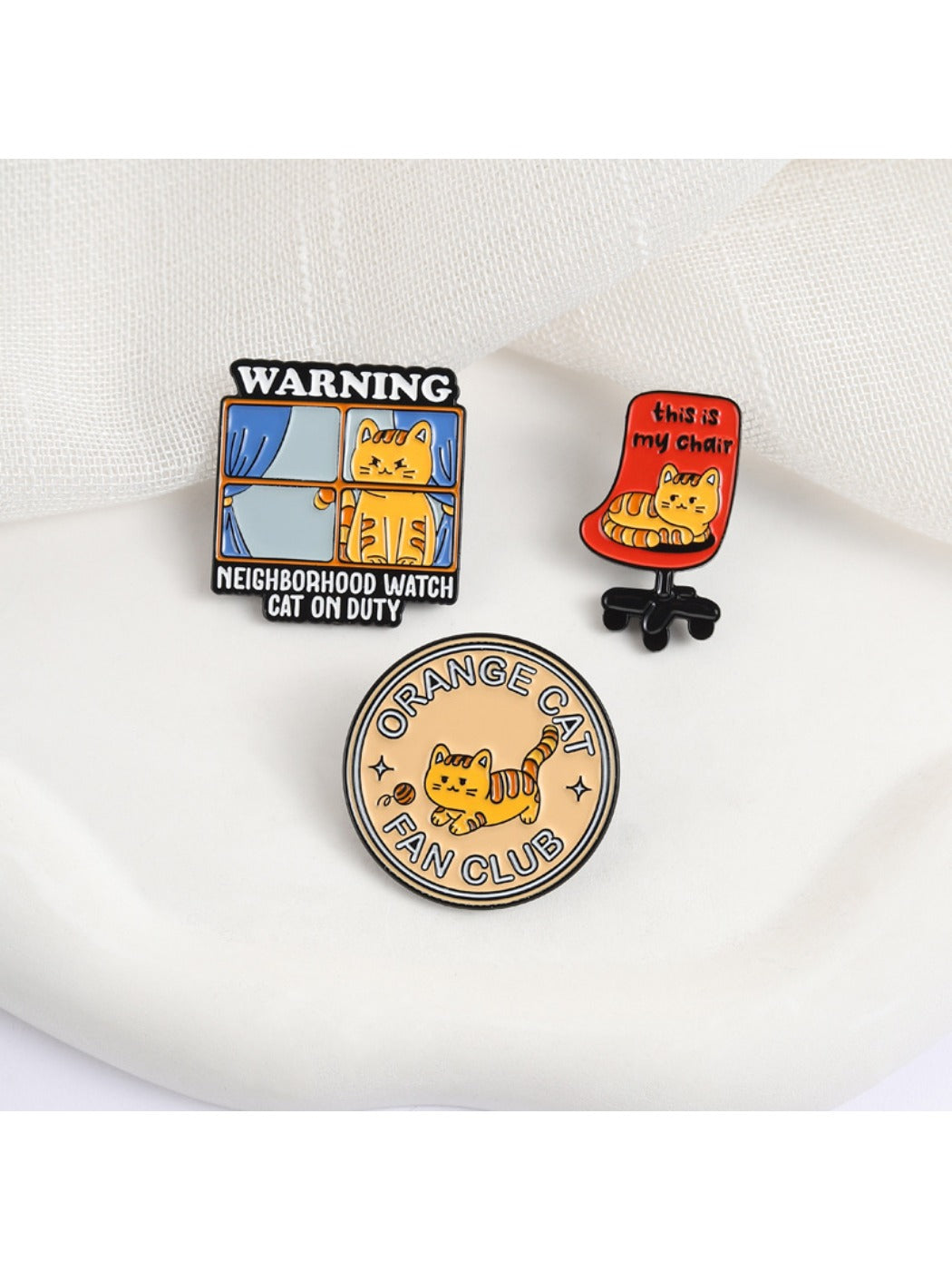 Close-up of Pinori orange cat enamel pin showing detailed design