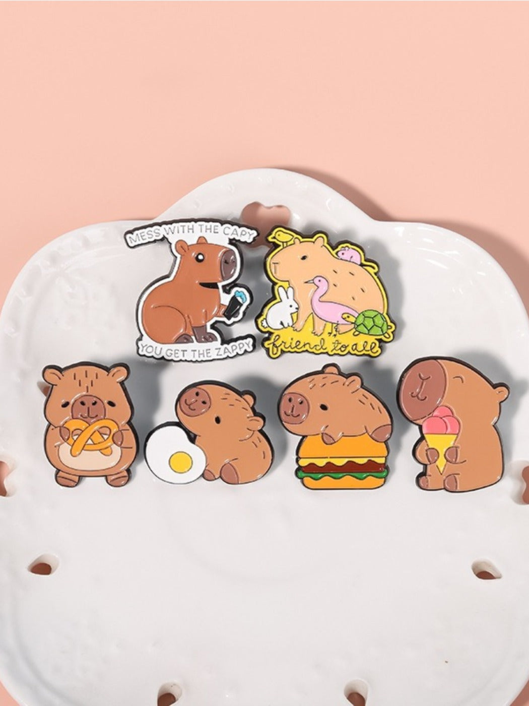 Close-up of Pinori capybara hamburger metal pin showing detailed enamel colors