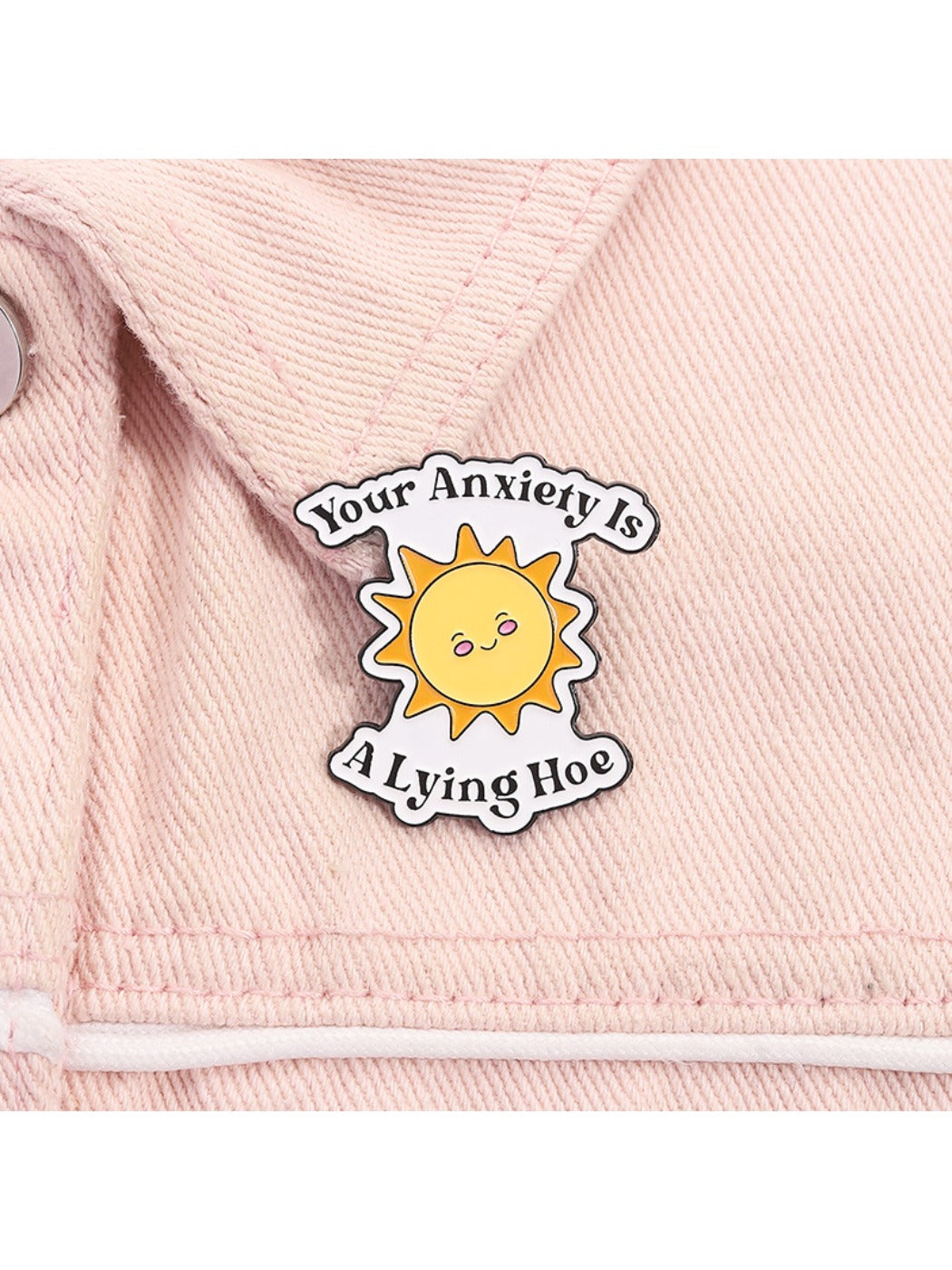 Pinori motivational sun brooch displayed on a black fabric surface