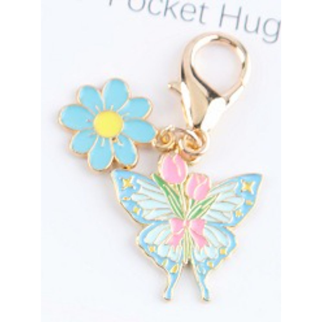 Hand holding the Taphug Floral Butterfly Charm Pocket Hug with visible details