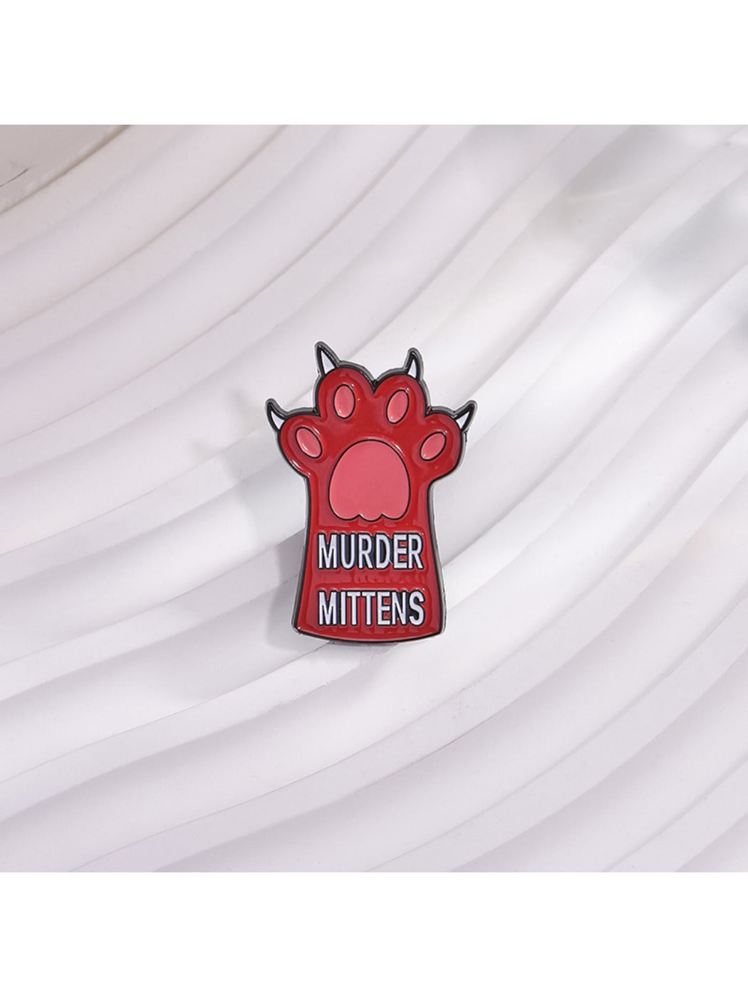 Pinori animal pin displayed on a fabric surface highlighting its size and shape