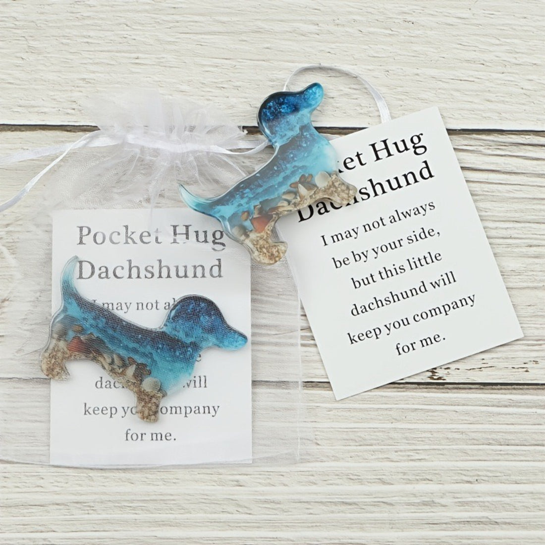 Close-up of Taphug Little Dachshund Pocket Hug plush showing detailed face and ears