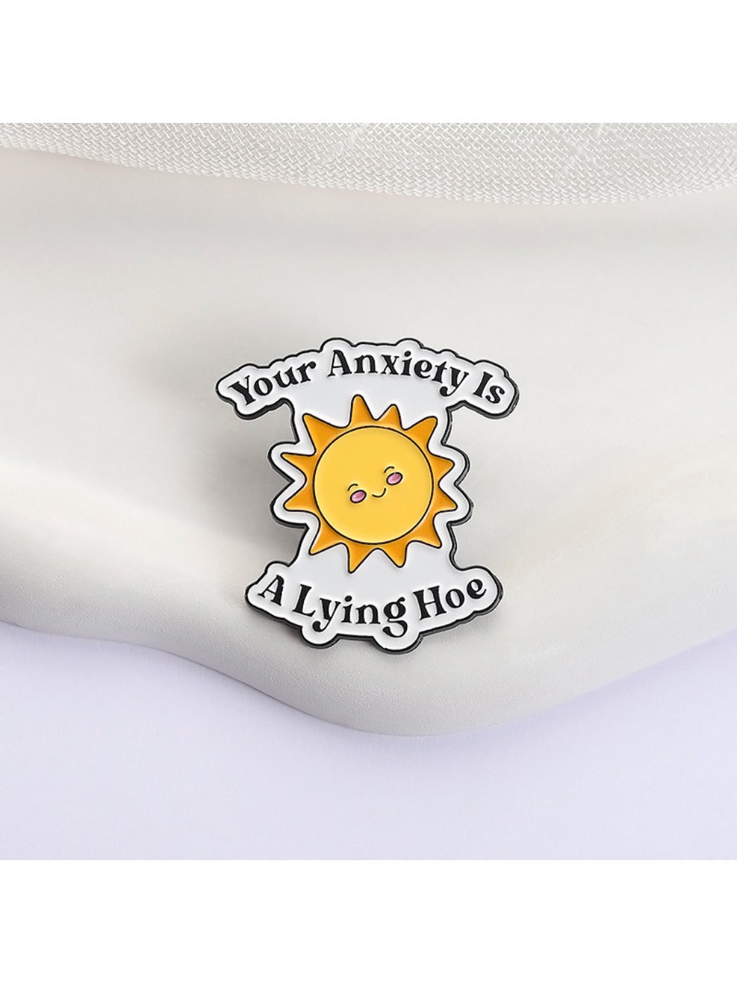 Close-up of Pinori sun brooch showing detailed enamel colors and cheerful expression