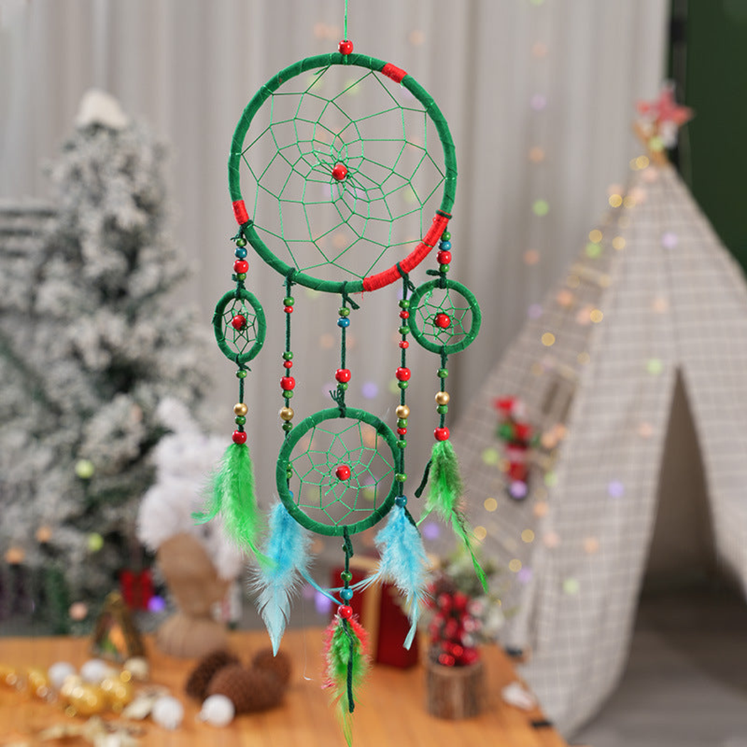 Green dreamcatcher with nested web-like hoops and colorful hanging strands in a room setting