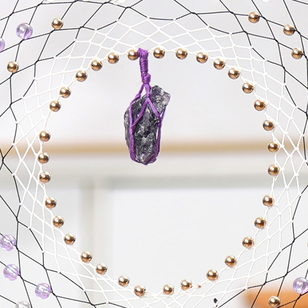 Close-up of the inner web, gold-tone bead-look ring and central stone-look pendant