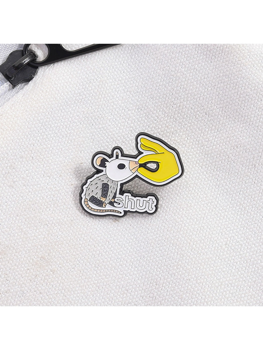 White lab rat metal pin badge attached to a backpack strap