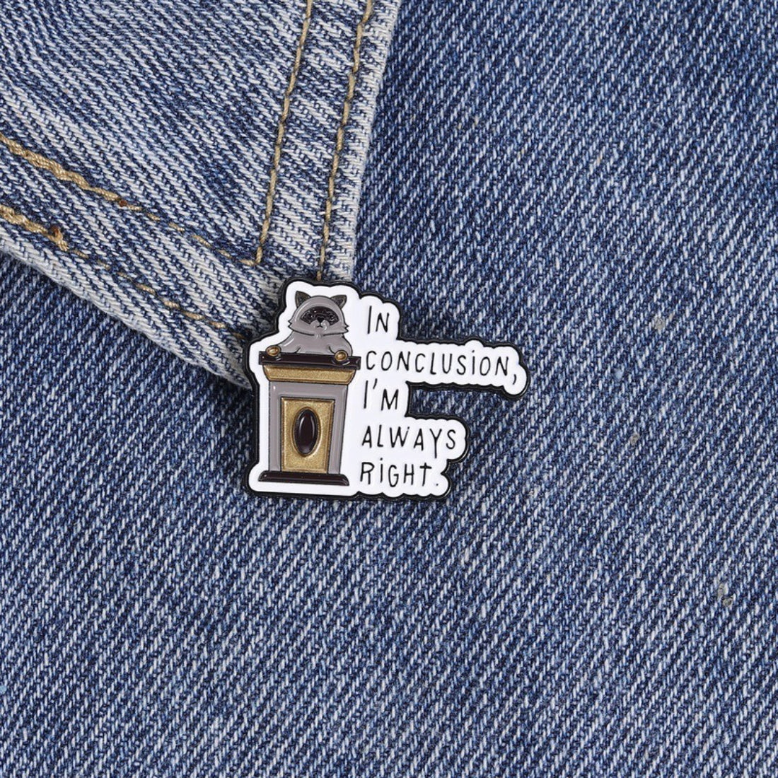 Pinori raccoon quote pin displayed on a denim jacket pocket