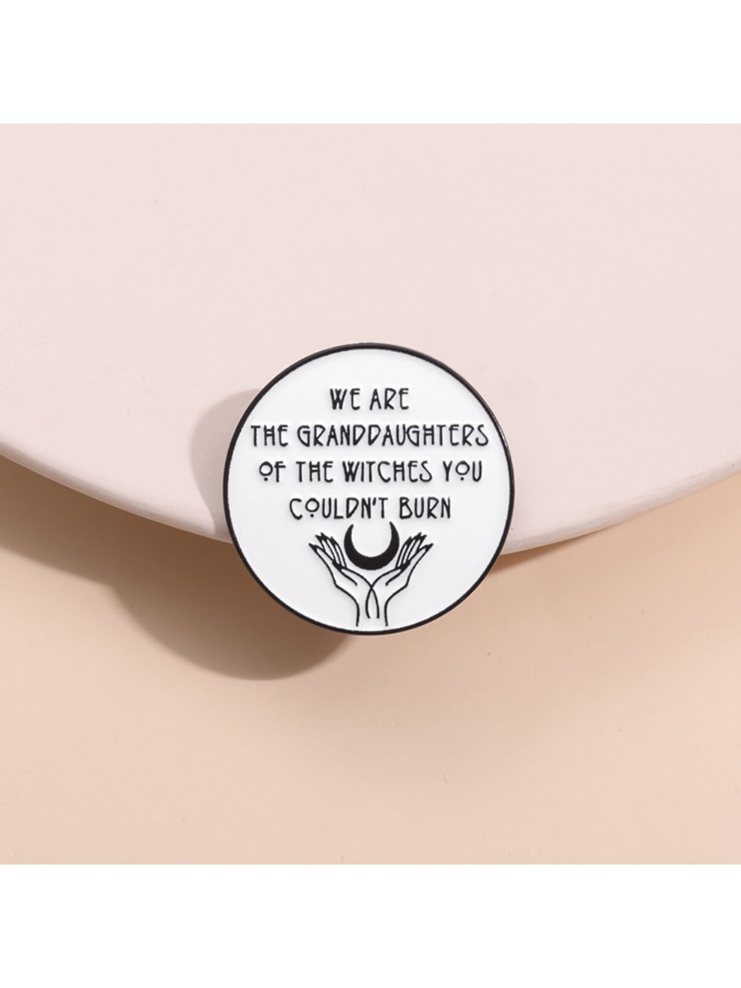 Close-up of Pinori Girl Power Unburnable Badge Pin with pink and gold design