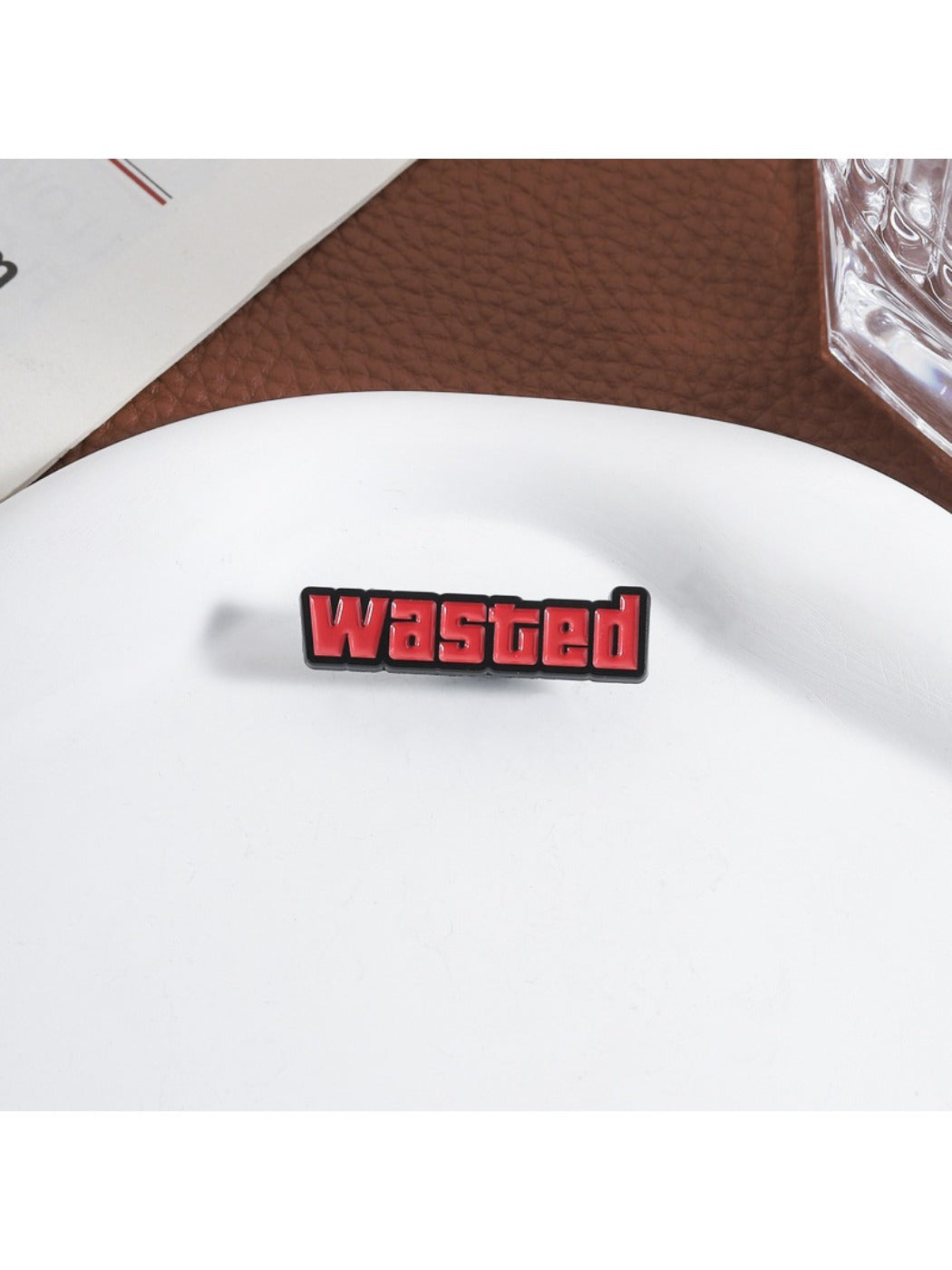 Pinori 'Wasted' pin attached to a backpack strap in natural light