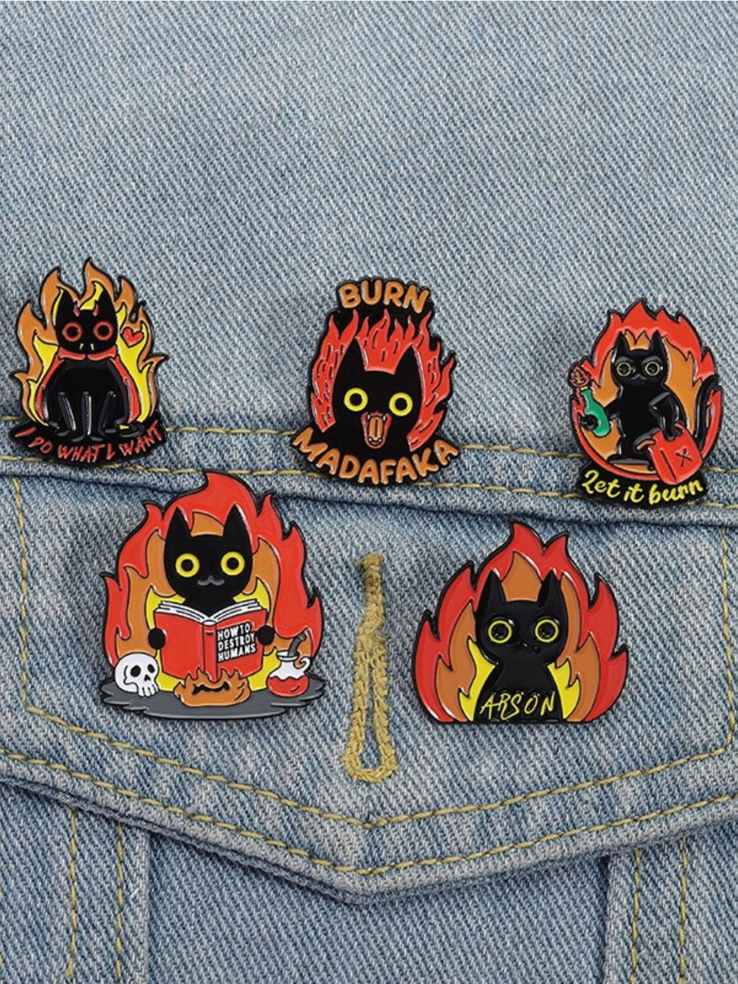 Pinori black cat badge with flame design held in hand for scale