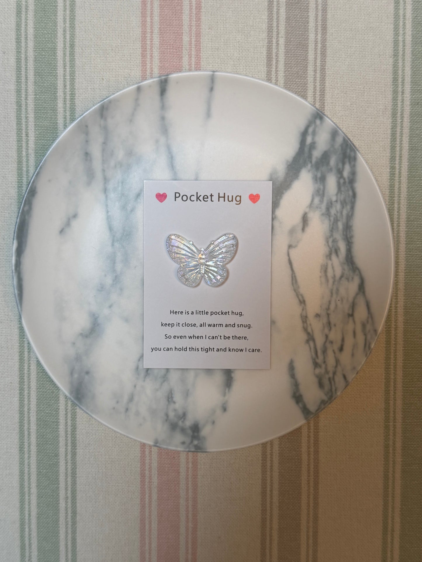 Lightweight polyester butterfly token next to the folded pocket hug card