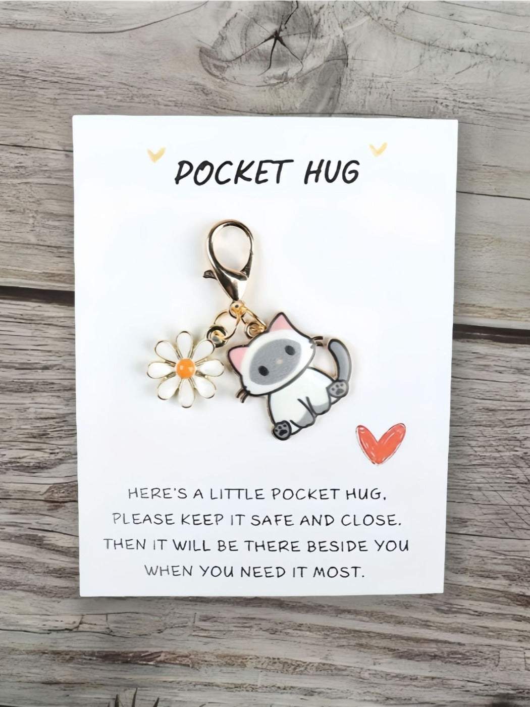 Taphug Pocket Hug keychain with cartoon cat charm displayed on a wooden surface