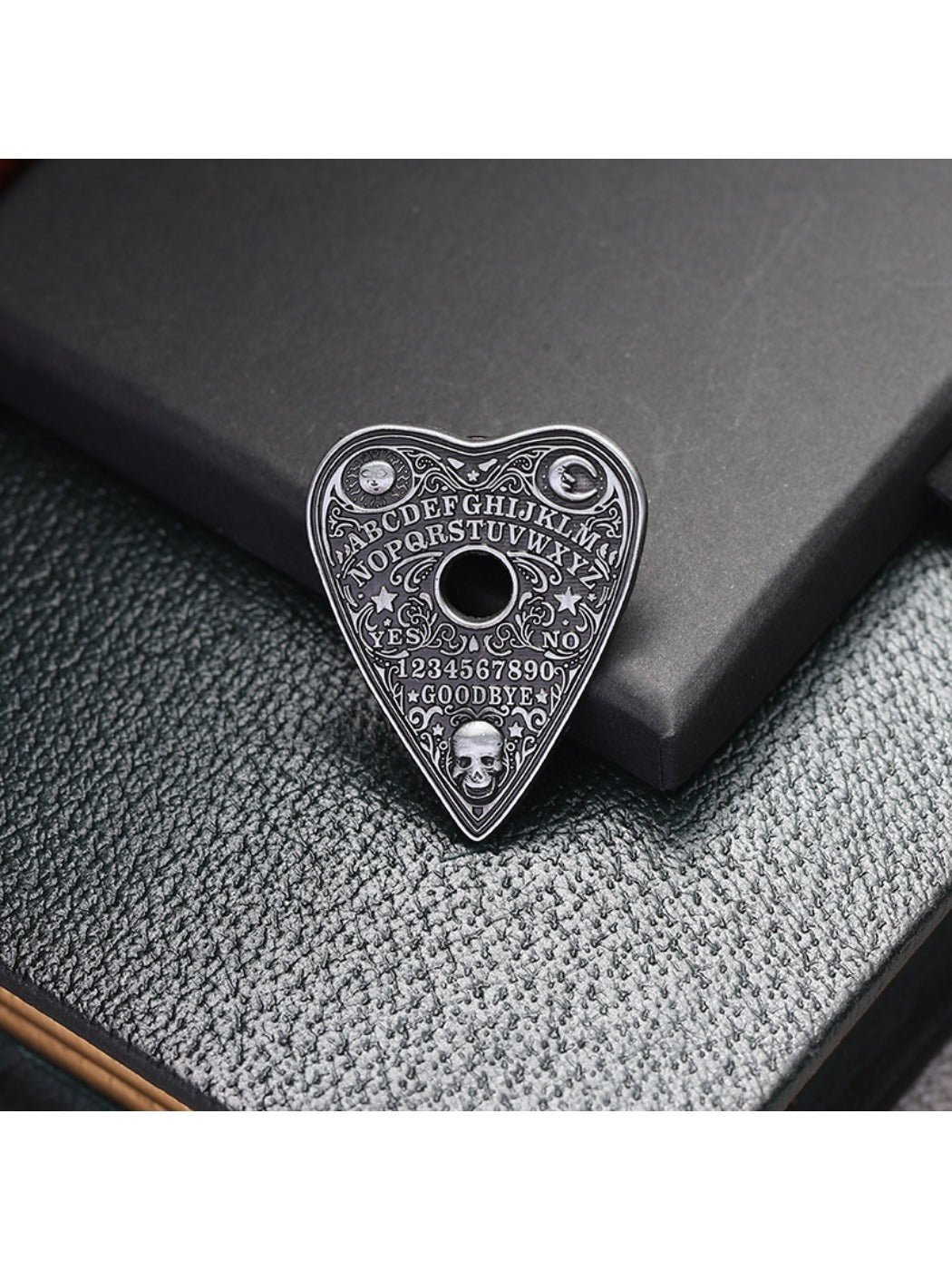 Close-up of Pinori black punk metal heart pin badge showing textured surface