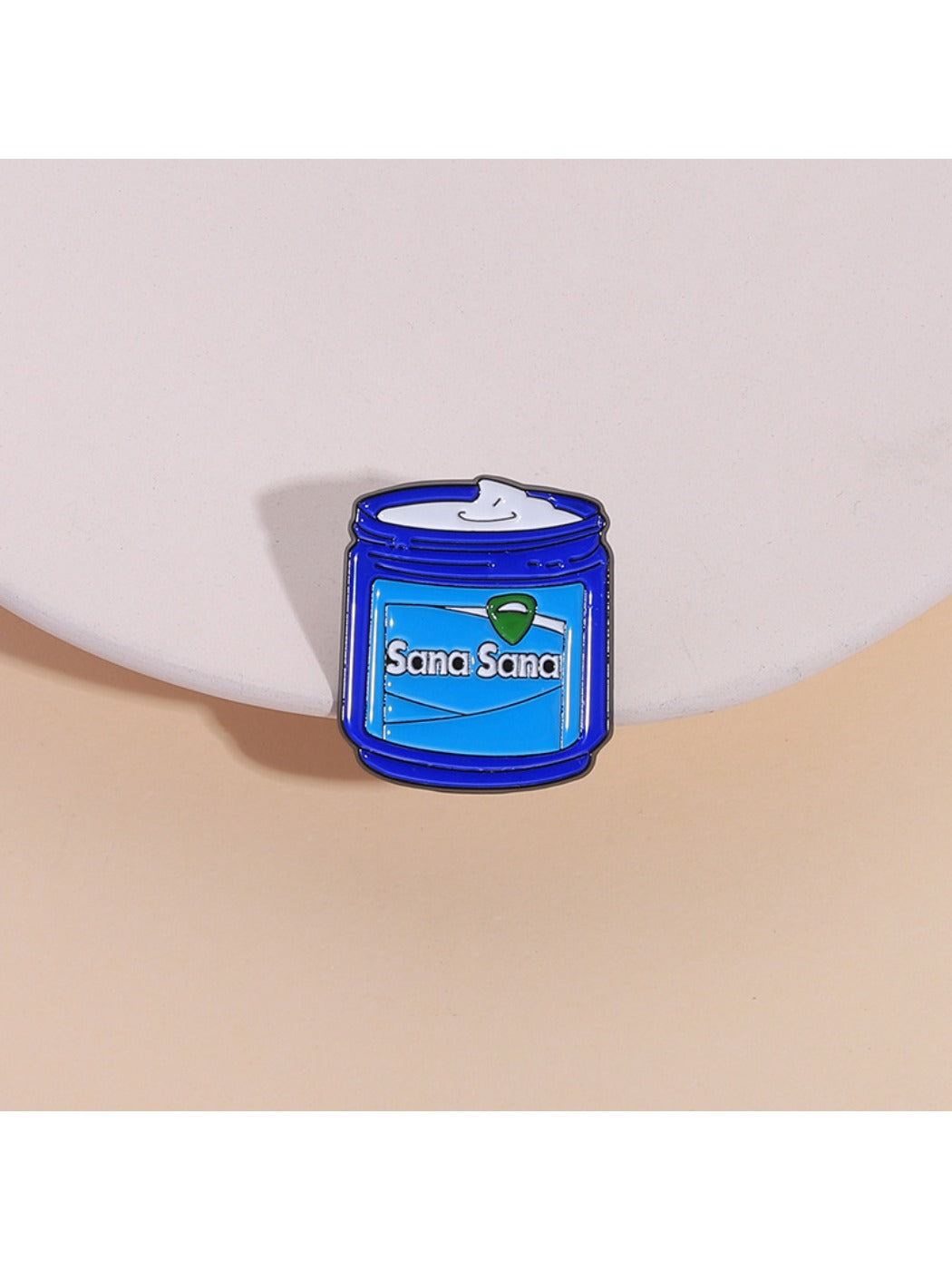 Close-up of Pinori blue cream jar metal brooch with detailed enamel finish