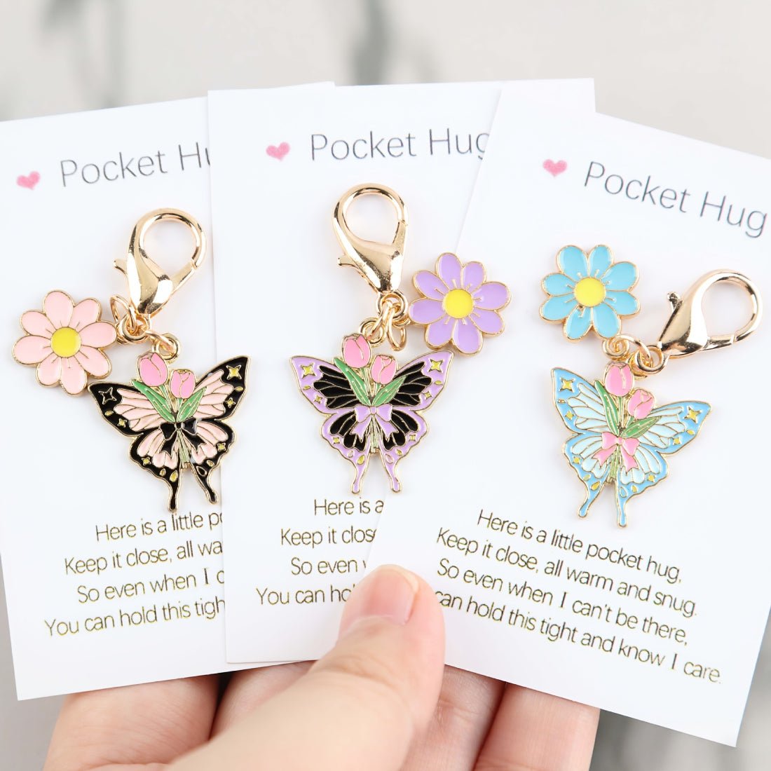 Close-up of the butterfly charm with floral patterns on the Taphug Pocket Hug