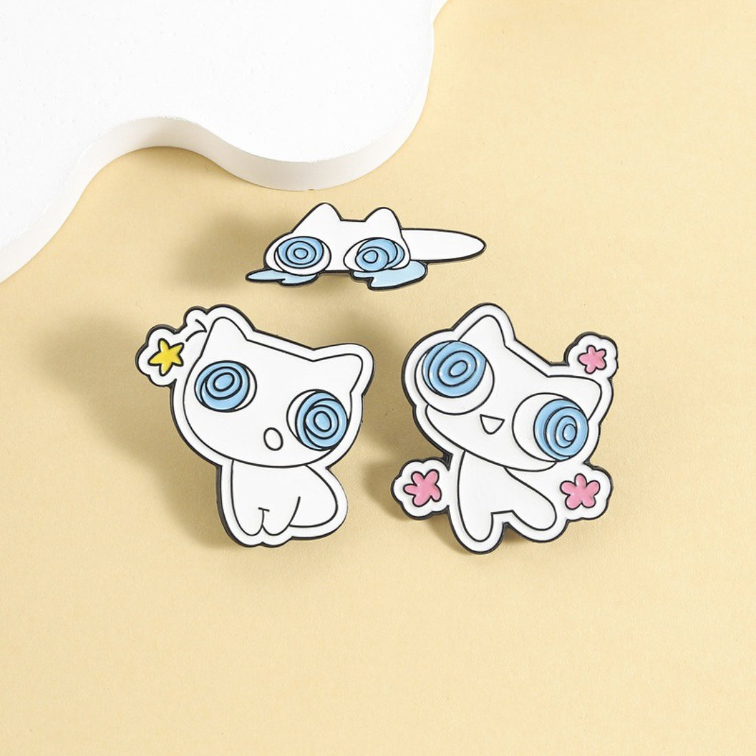 Pinori Dizzy Eye White Cat enamel pin on black backing card