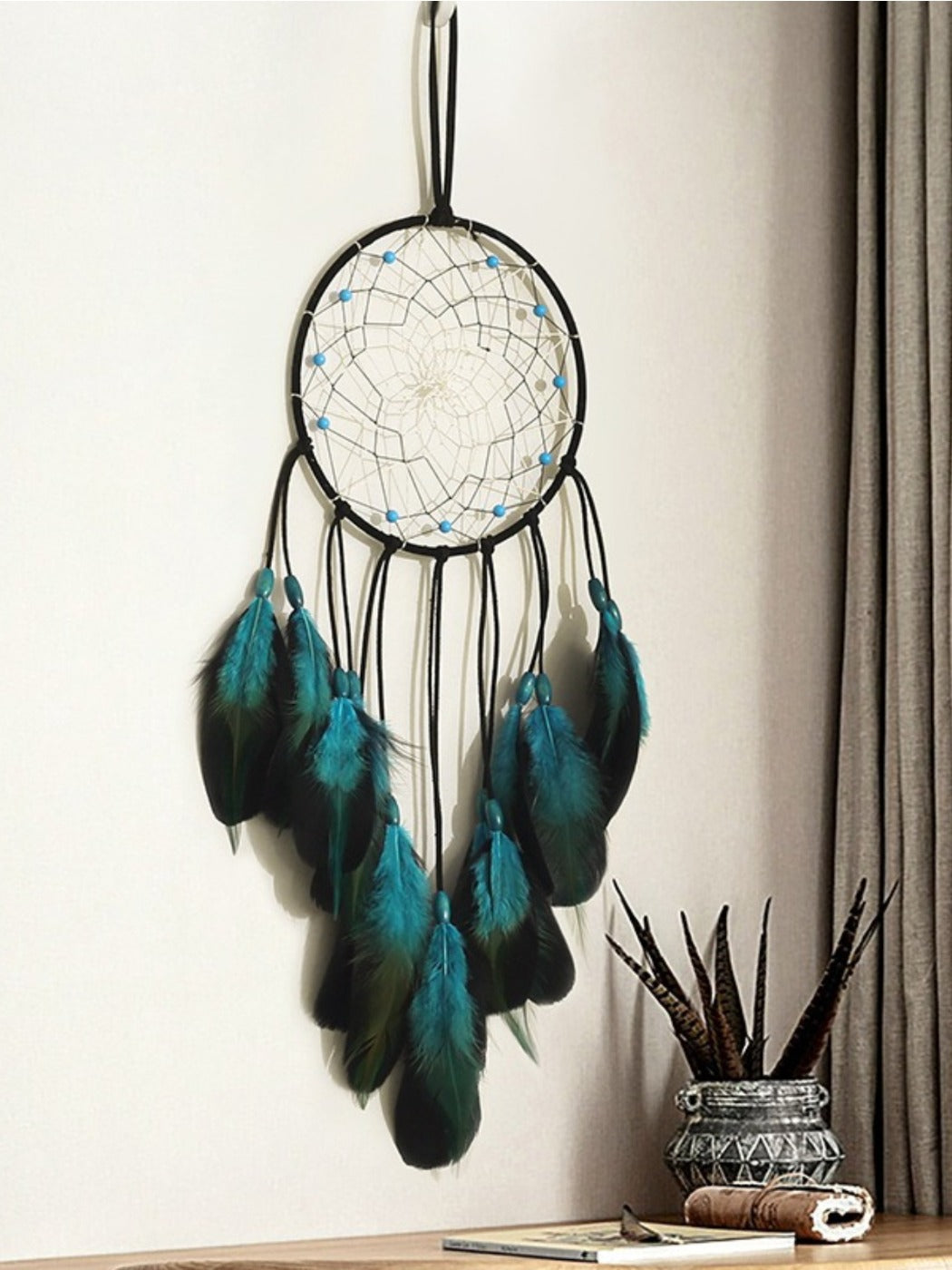 Close-up of blue feathers and beads on dreamcatcher wall decor