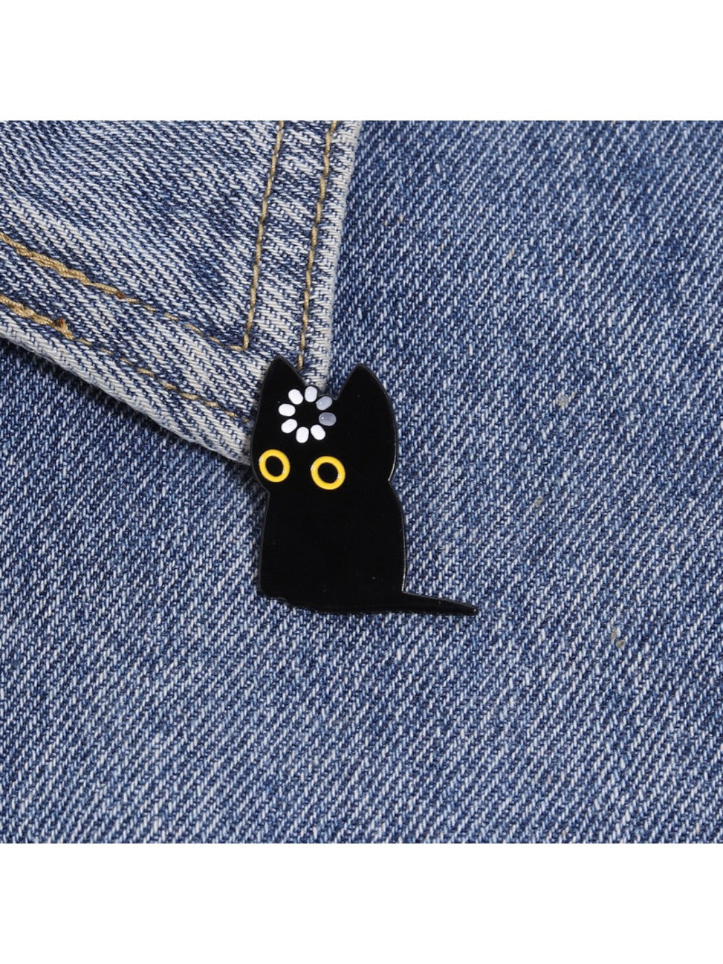 Pinori black cat brooch worn on a jacket lapel